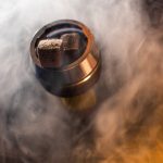 Close-up shot of hookah coal emitting smoke, creating a vibrant atmosphere.